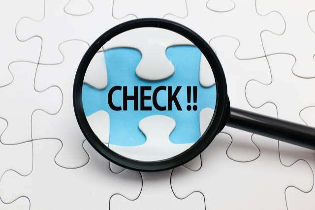 パズルの中のチェックの文字を覗くルーペ